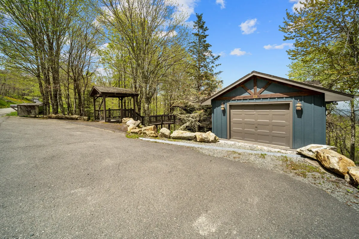 A tranquil yard scene with a charming gazebo, garage, and mature trees. The gazebo offers a sheltered space to relax while being immersed in nature, with a sense of privacy and peacefulness.